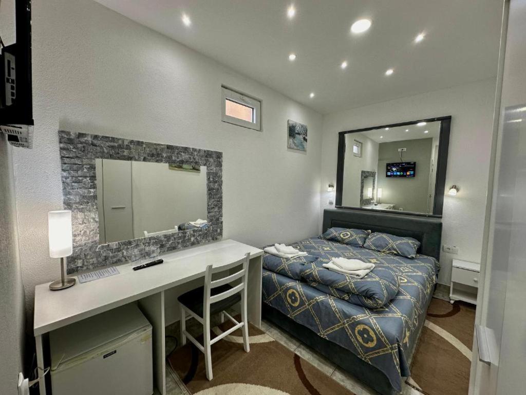 a bedroom with a bed and a desk and a mirror at Room 4A in Jošanička Banja