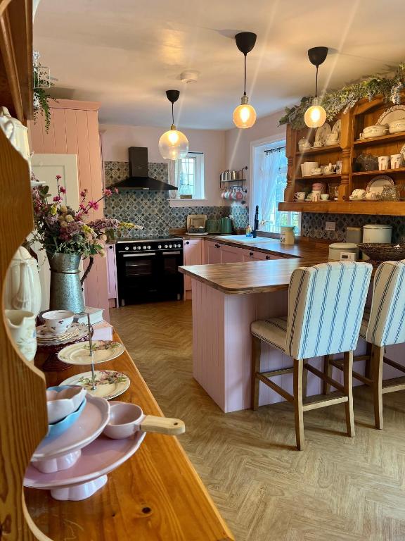a kitchen with a wooden table and blue chairs at 5 - Spacious Countryside House for Families & Groups in Pont Sticill