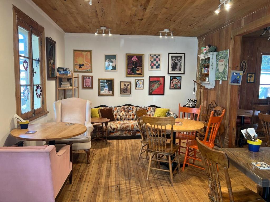 a living room with a couch and tables and chairs at Serene Getaway Rawdon Nordic Spa, Sauna, Nature and Pool in Rawdon
