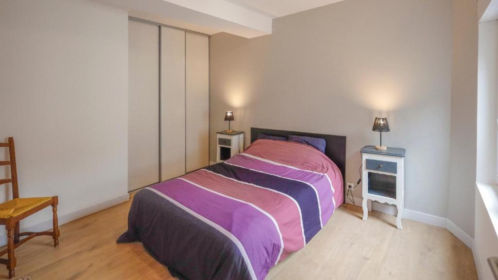 une chambre avec un lit et deux tables de nuit dans l'établissement La maison au cœur médiéval, à Domfront