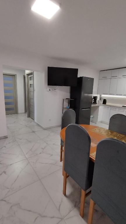 a kitchen with a wooden table and chairs at Apartament I Na Słonku in Dzierzgoń