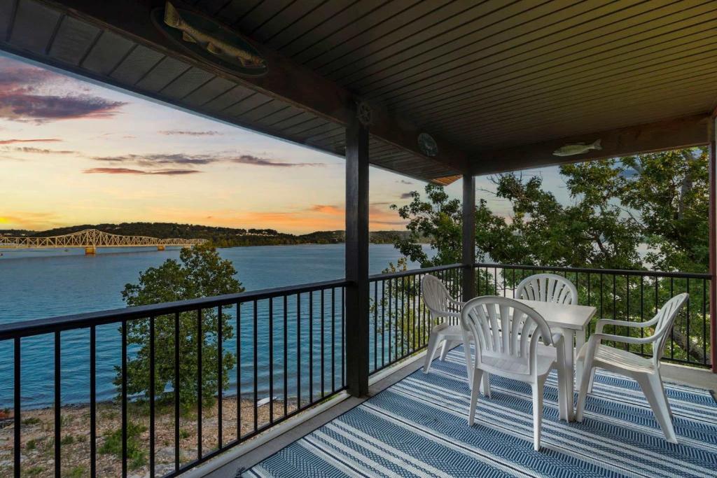 a porch with two chairs and a table with a view of the water at Lakeview At Table Rock in Kimberling City