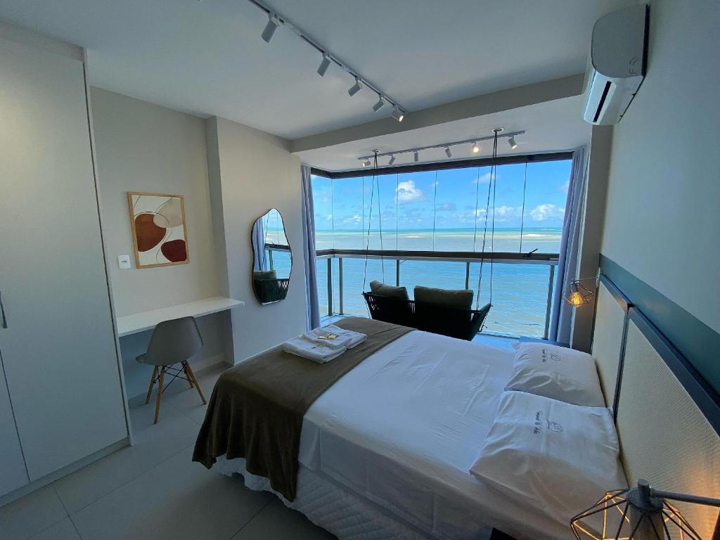a bedroom with a large bed and a large window at Diamond Beach in Vila Velha