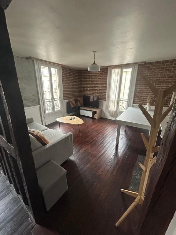 een woonkamer met een bank en een tafel bij WAROUX - Appartement Rennes 6P in Rennes