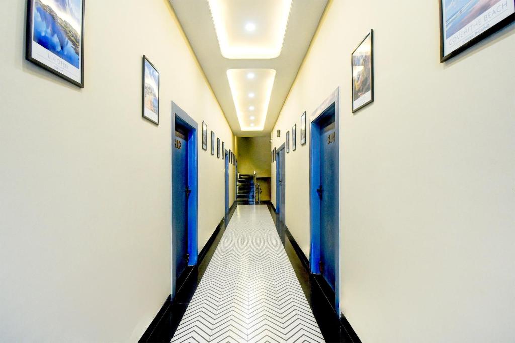 ein Flur eines Krankenhauses mit blauen Türen in der Unterkunft Hotel O Palm Inn Durgapura Railway Station in Jaipur