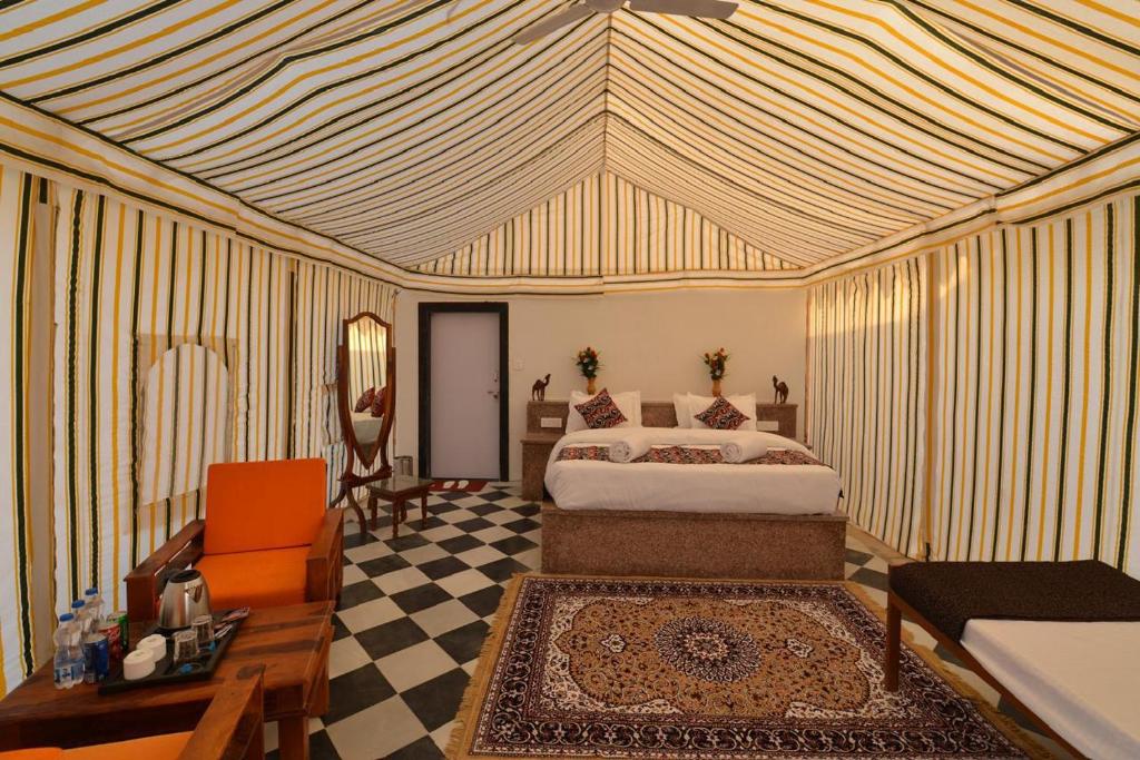 a bedroom with a bed and a desk and a couch at Kesariya Heritage Resorts in Jaisalmer