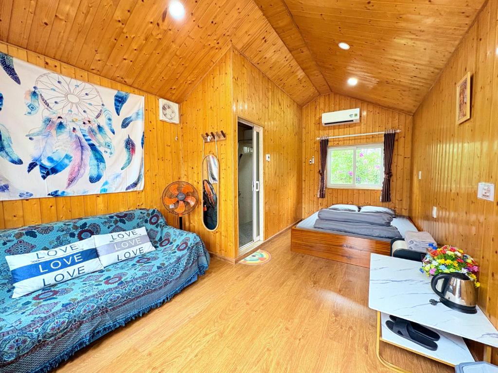 a room with two beds and a couch in it at Henisi Homestay Măng Đen in Kon Von Kla