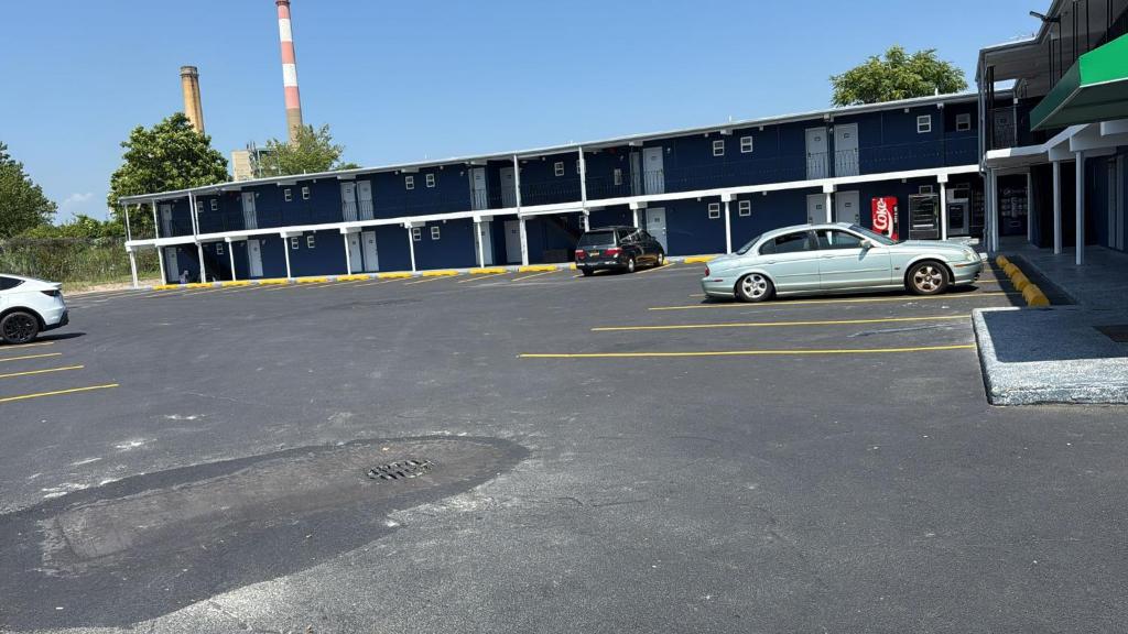 a parking lot with cars parked in front of a building at Island Motor Inn in Island Park