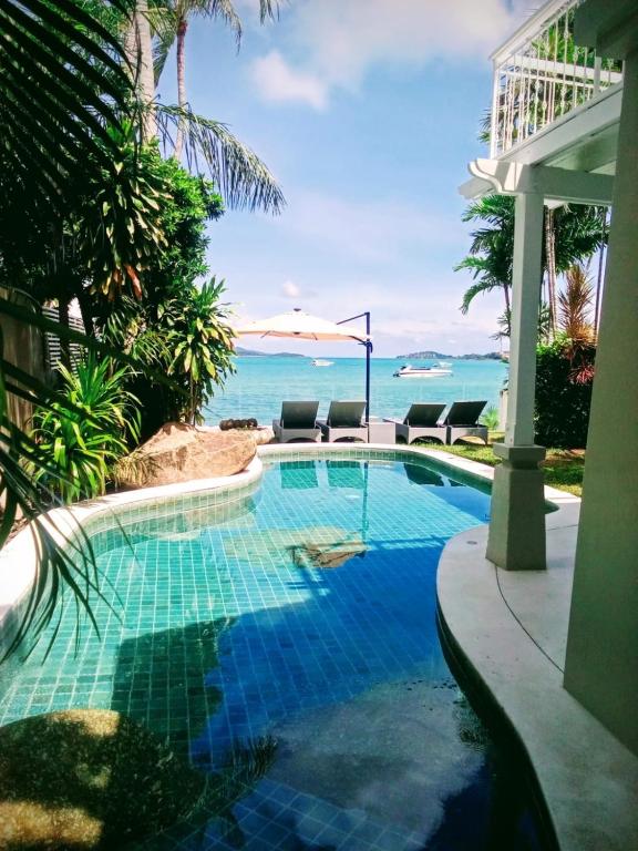 a swimming pool with a view of the ocean at Beachfront Villa Charmant With Private Pool in Koh Samui
