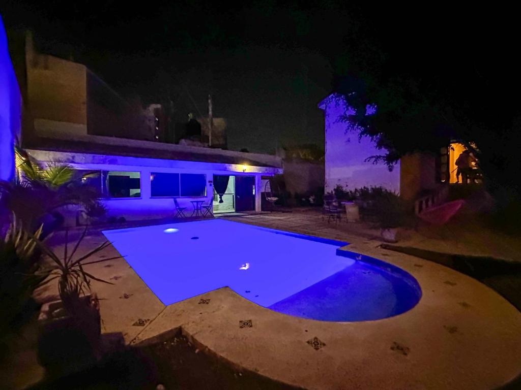 an empty swimming pool in front of a house at night at Escapada Calida para 4 en Zona Campestre Merida in Chuburná de Hidalgo