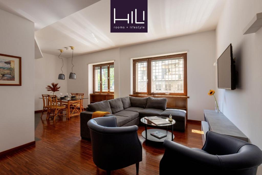 un soggiorno con un divano, sedie e un tavolo di Casa Sacchi by Hili a Roma