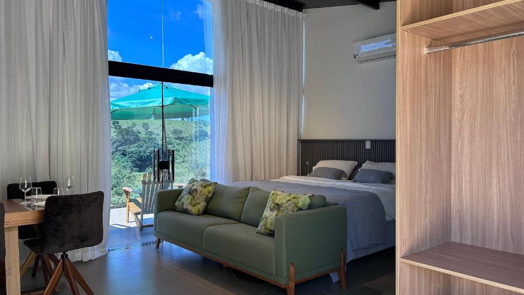 una camera da letto con un letto, un divano e una finestra di Rancho Ipês do Lago a Socorro