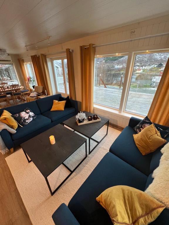 un soggiorno con un divano blu e un tavolo di My Home Kaldfjorden a Tromsø
