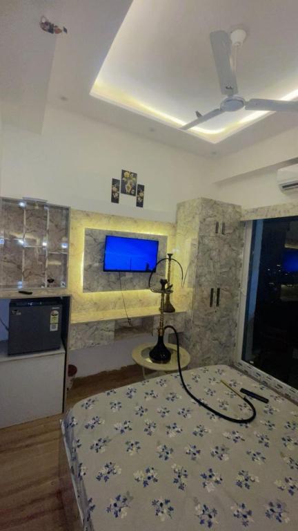 een slaapkamer met een bed en een tv aan de muur bij Love passion in Greater Noida