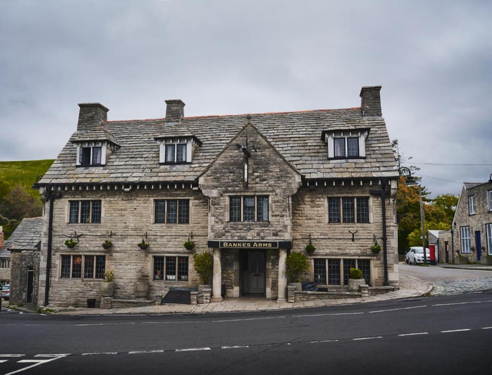 an old stone building on the corner of a street at Bankes Arms Hotel in Wareham