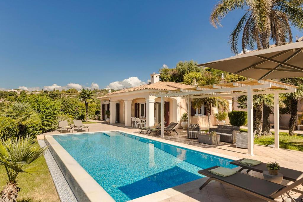 a villa with a swimming pool and a house at Dina by Vintage Travel in Kaligata