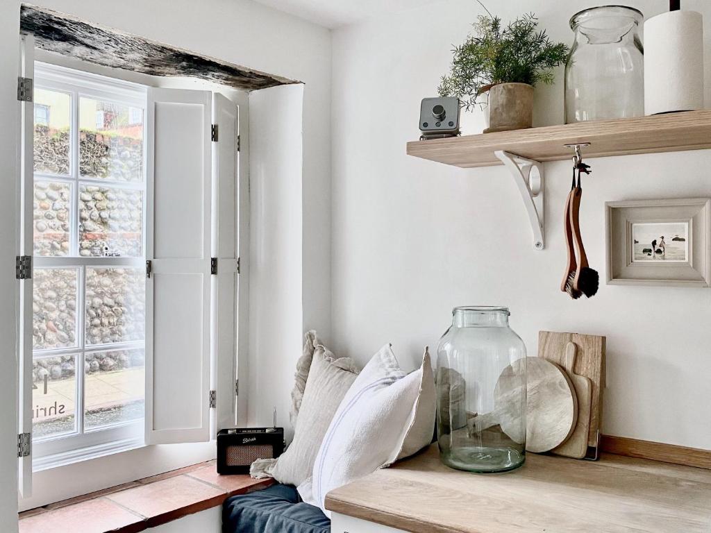 a room with a window and a vase on a bench at Shrimp Cromer in Cromer