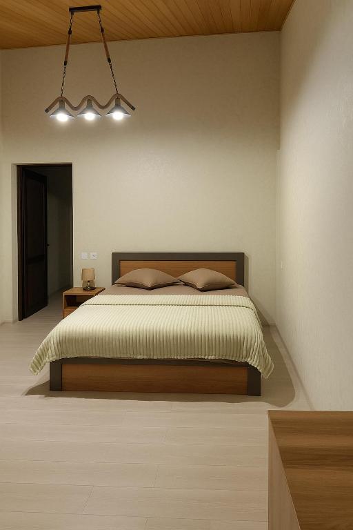 a bedroom with a bed and a chandelier at HOTEL RANCHO UPLISTSIKHE სასტუმრო რანჩო უიფლისციხე in Uplistsikhe
