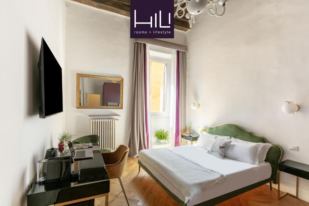 a bedroom with a bed and a desk and a window at Residenza Il Vicolo by Hili in Rome