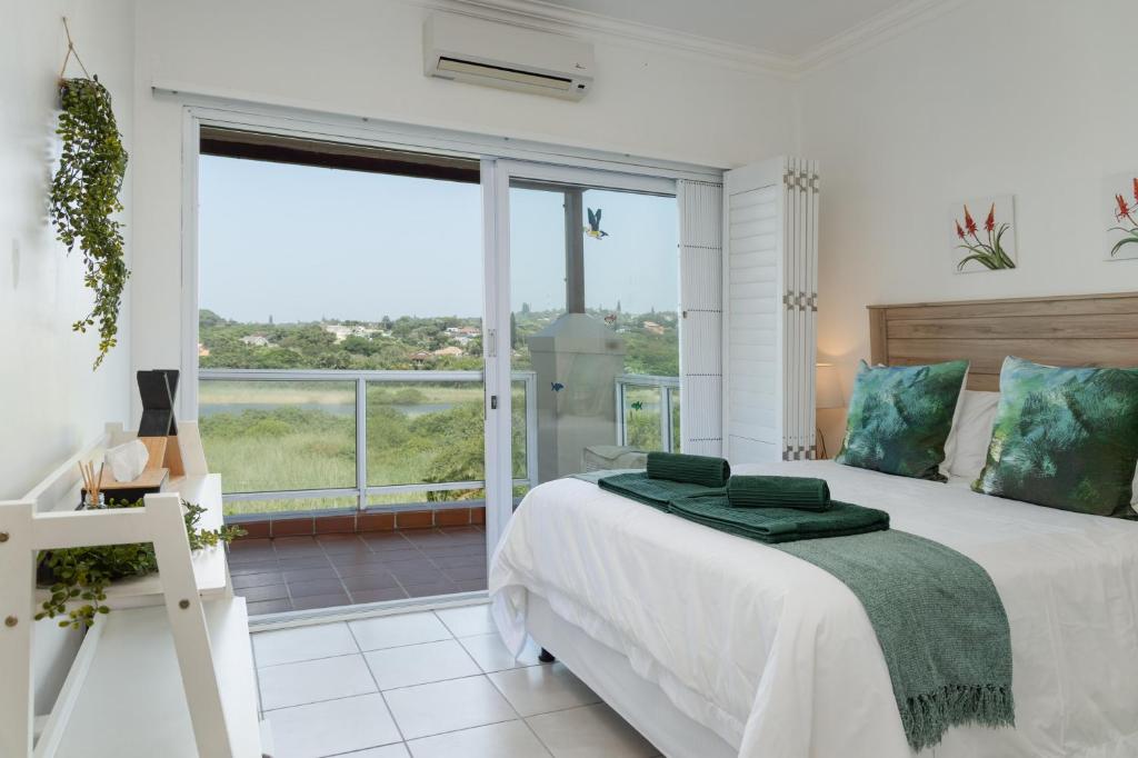 マーゲートにあるLuxurious Lagoon Retreatのベッドと大きな窓のある白い寝室