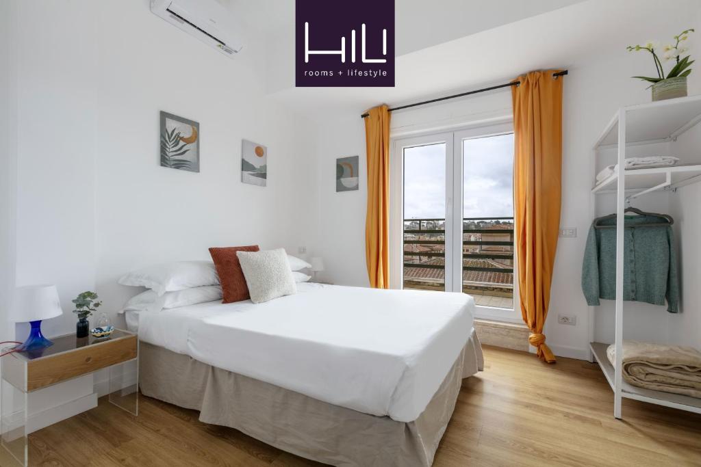 a white bedroom with a bed and a window at Casa Vespi by Hili in Rome