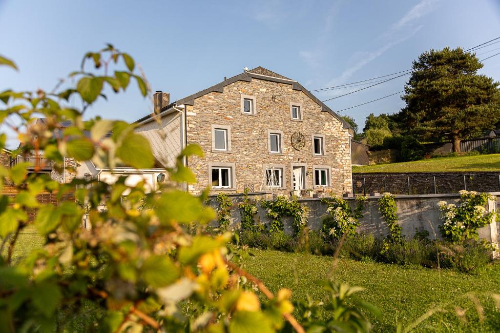 an old brick building with a clock on it at l'hôt'antique in Vielsalm