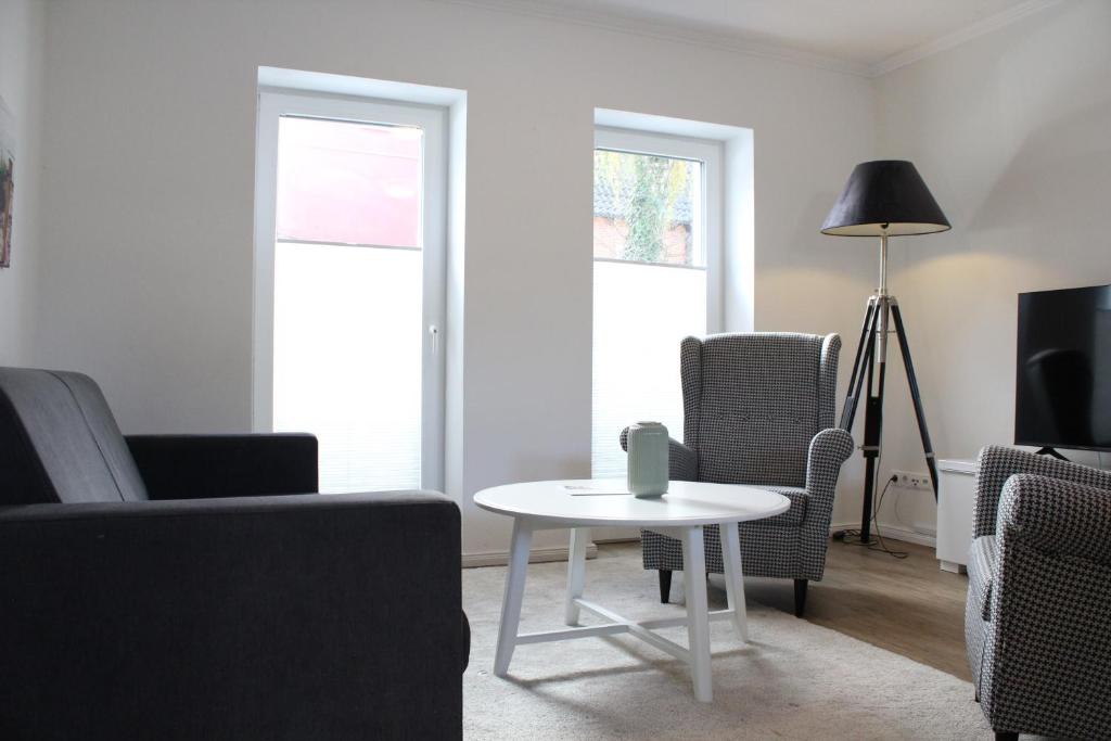 a living room with a white table and chairs at Fairschlafen am Hafen in Neustadt in Holstein