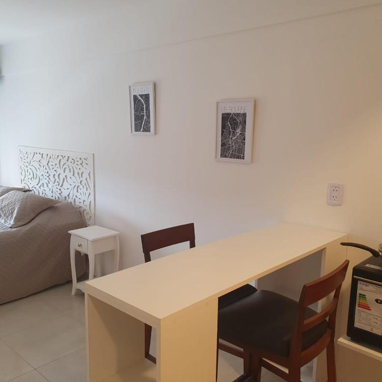 a desk in a room with two chairs and a bed at Monoambiuente equipado para 2 personas en San Miguel de Tucumán in San Miguel de Tucumán