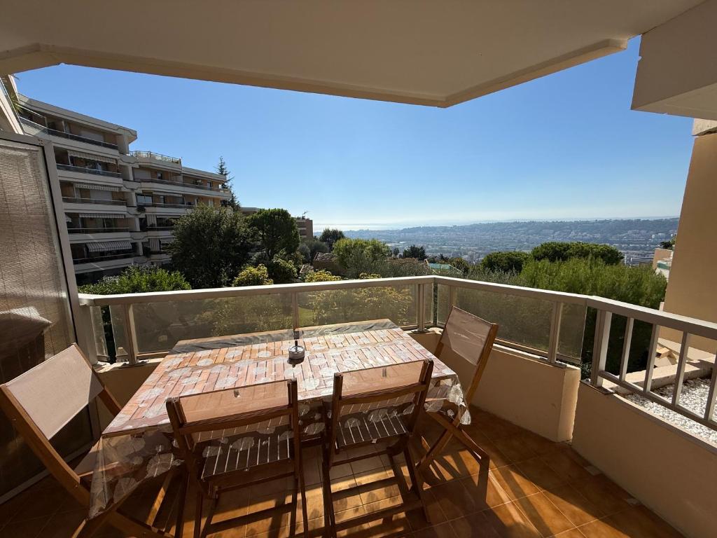 Una mesa y sillas en un balcón con vista. en Le Cocon, en Niza