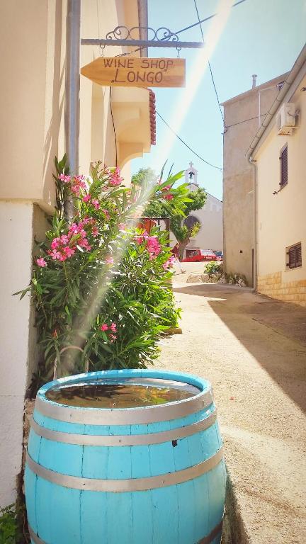 a water fountain in a barrel on the side of a building at Gospoja Park & Beach Apartment Vrbnik in Vrbnik