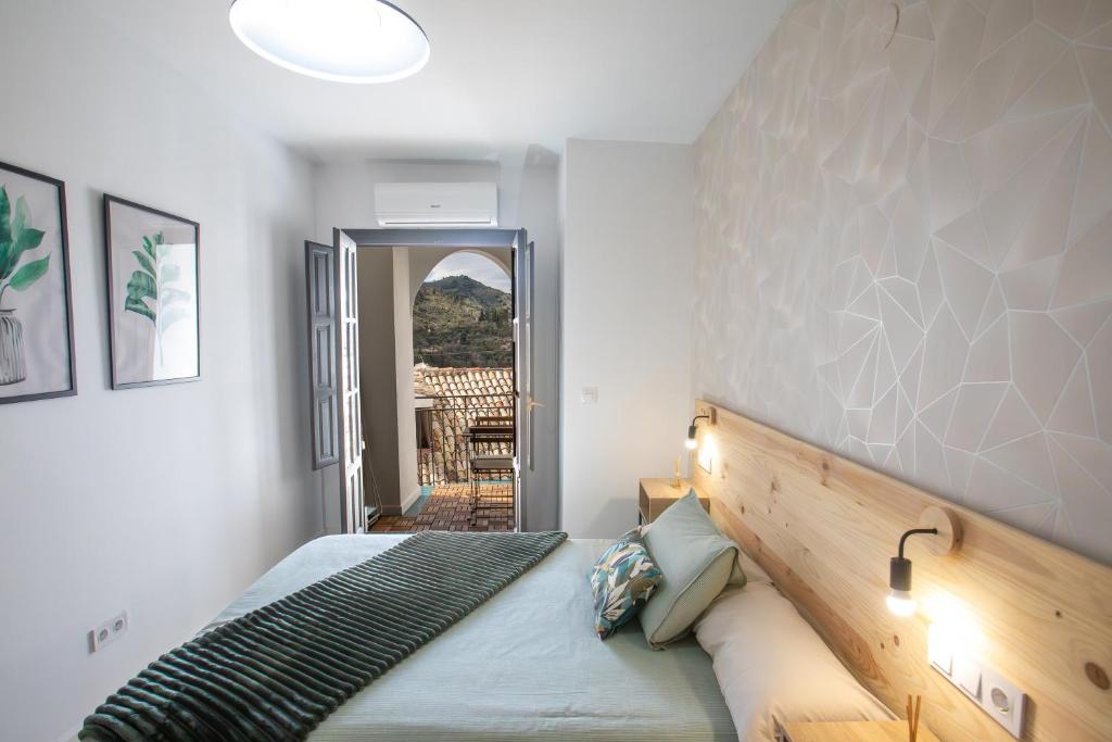 a bedroom with a bed with a wooden headboard at Apartamento Coque con balcón y preciosas vistas a la montaña in Cazorla