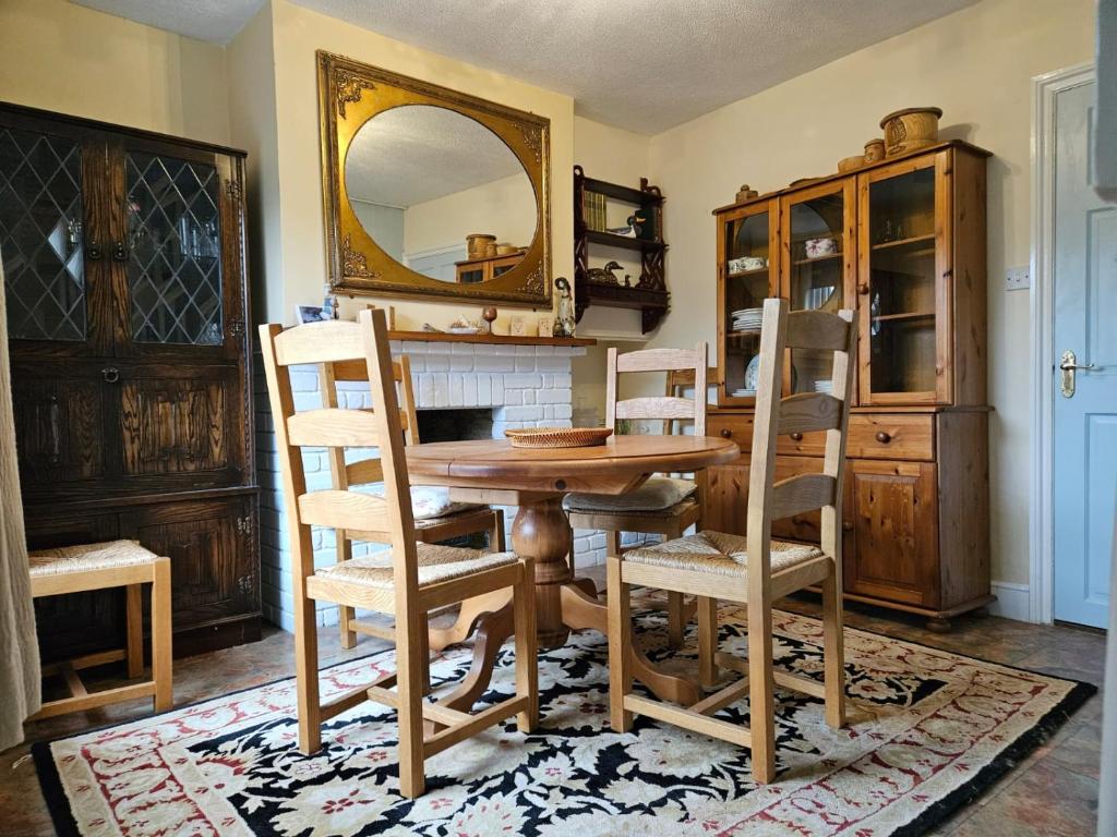 a dining room with a table and chairs and a mirror at B&B Rooms in terraced house in Sudbury centre in Sudbury
