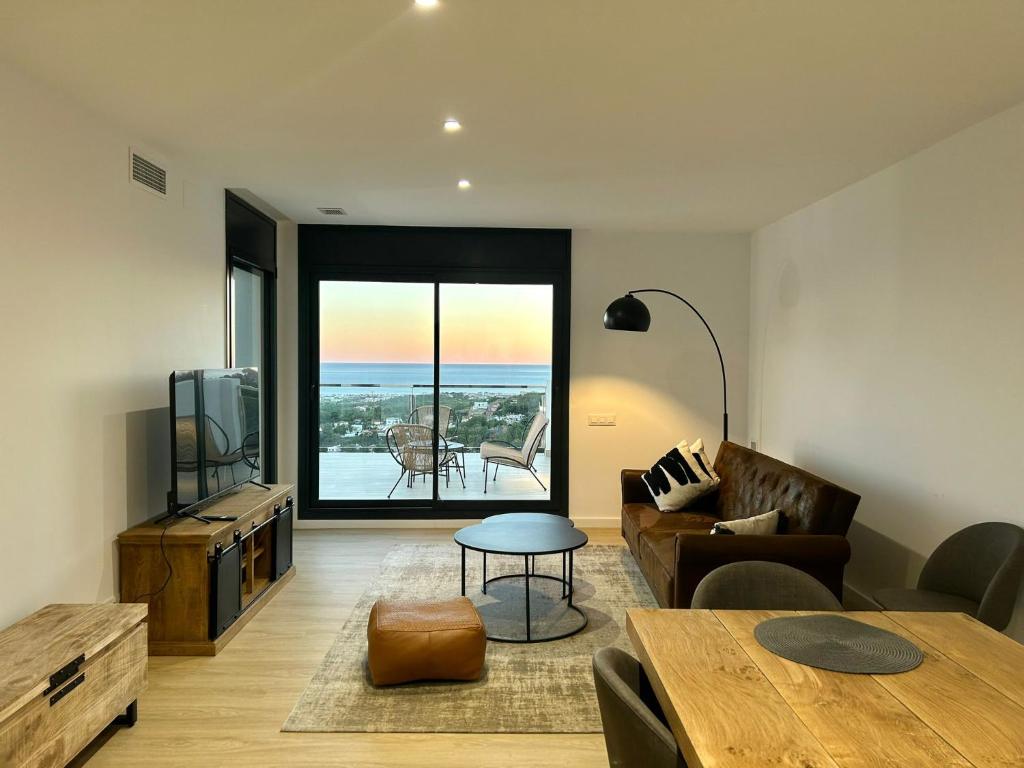 a living room with a couch and a table at Les Flors de Cunit Villa Edelweiss in Cunit