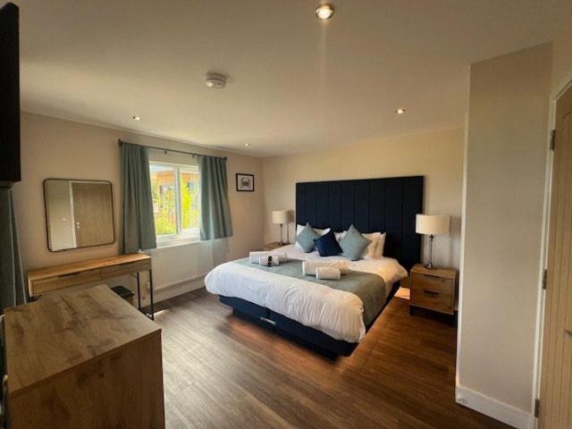 a bedroom with a large bed and a television at Sea Marge Seaview Lodges in Overstrand