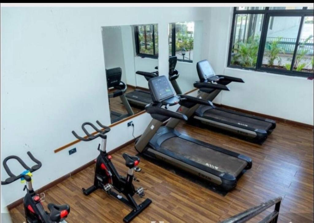 a gym with several exercise bikes in a room at Studio apartment in Gatunga