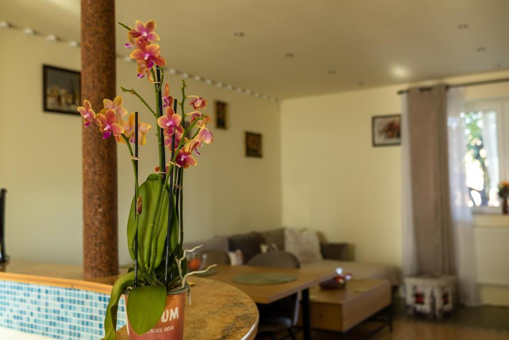a vase with flowers on a table in a living room at Gusterita Hideaway in Sibiu