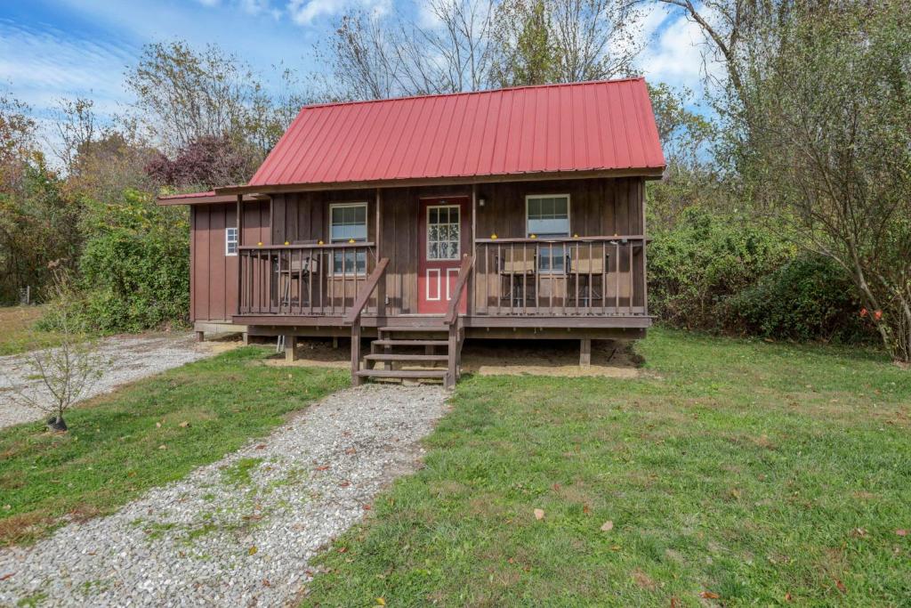a small house with a red roof and a porch at Cozy Cabin in New Lexington