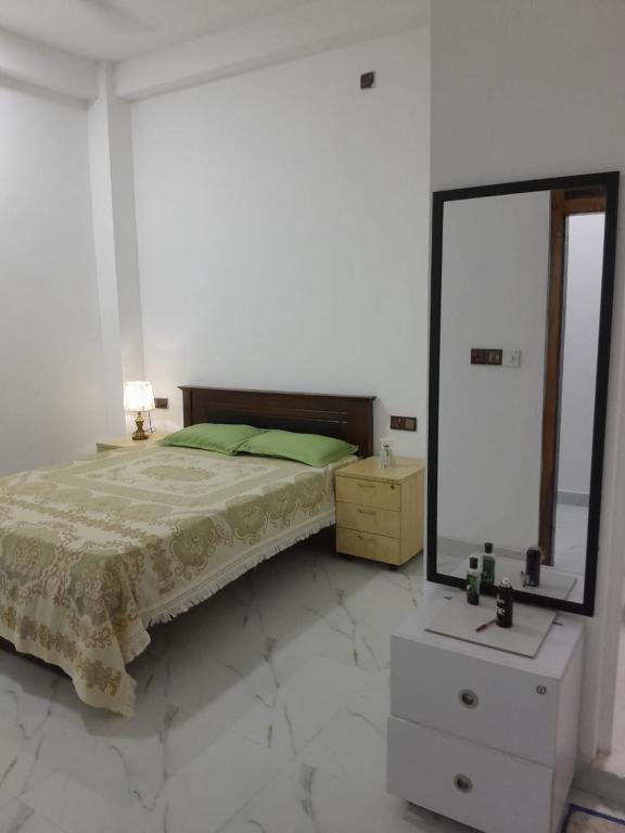 a bedroom with a bed with a mirror and a dresser at AJA Manzil in Watumulla