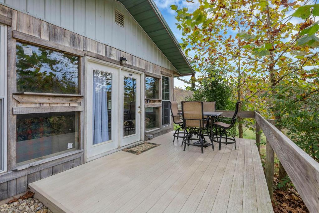 a wooden deck with a table and chairs on a house at Cabin with Character in New Lexington