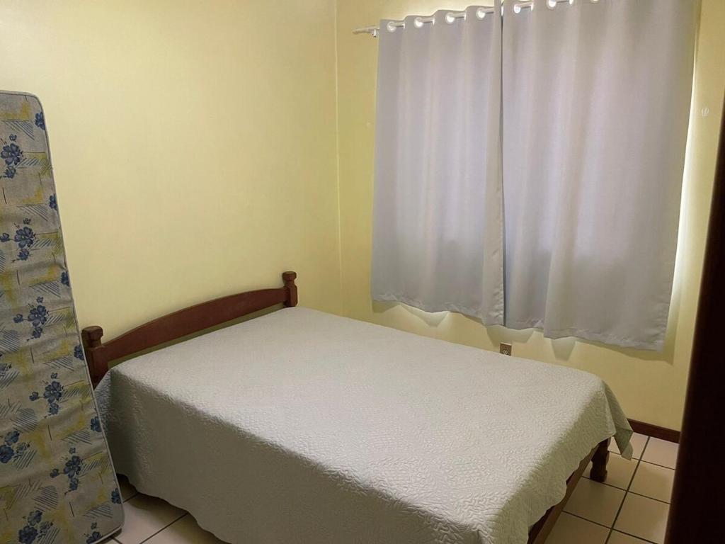 een kleine slaapkamer met een bed en een raam bij Apartamento Central Edifício Vale do Reno BC in Balneário Camboriú