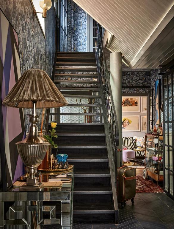 a staircase in a house with a table and a lamp at Revolverhotel in Visby
