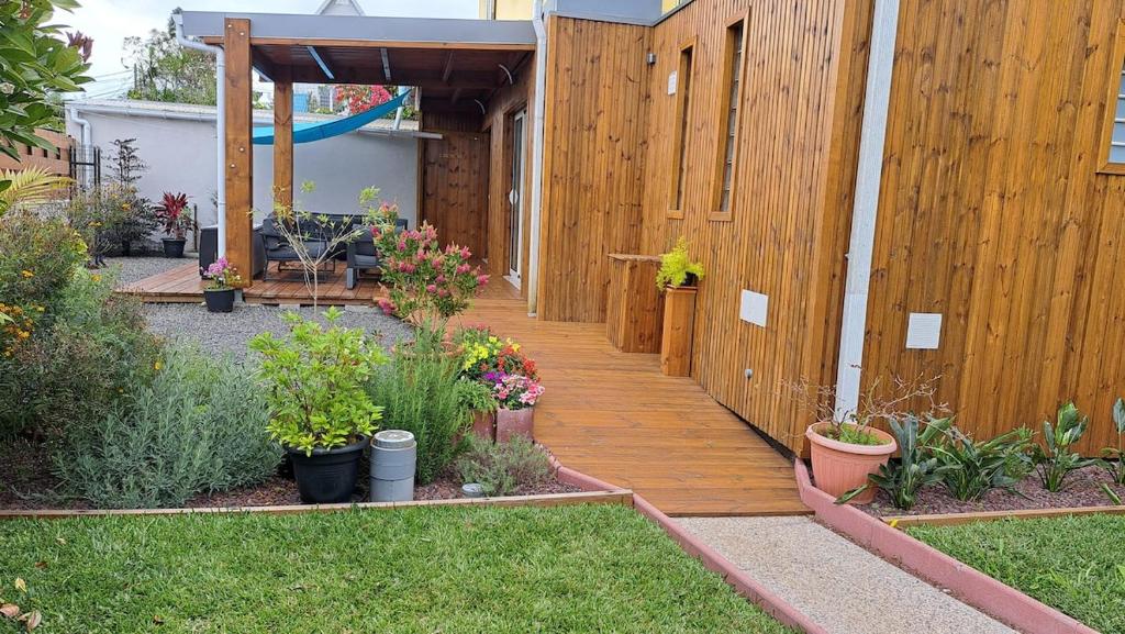 a wooden walkway in a backyard with plants at La Kaz Héliconias in Le Tampon