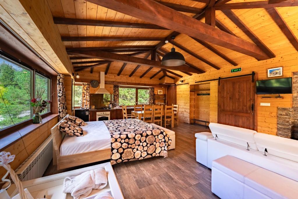 une chambre en rondins avec un lit et un salon dans l'établissement Abies Alba, à Yarema residence zone