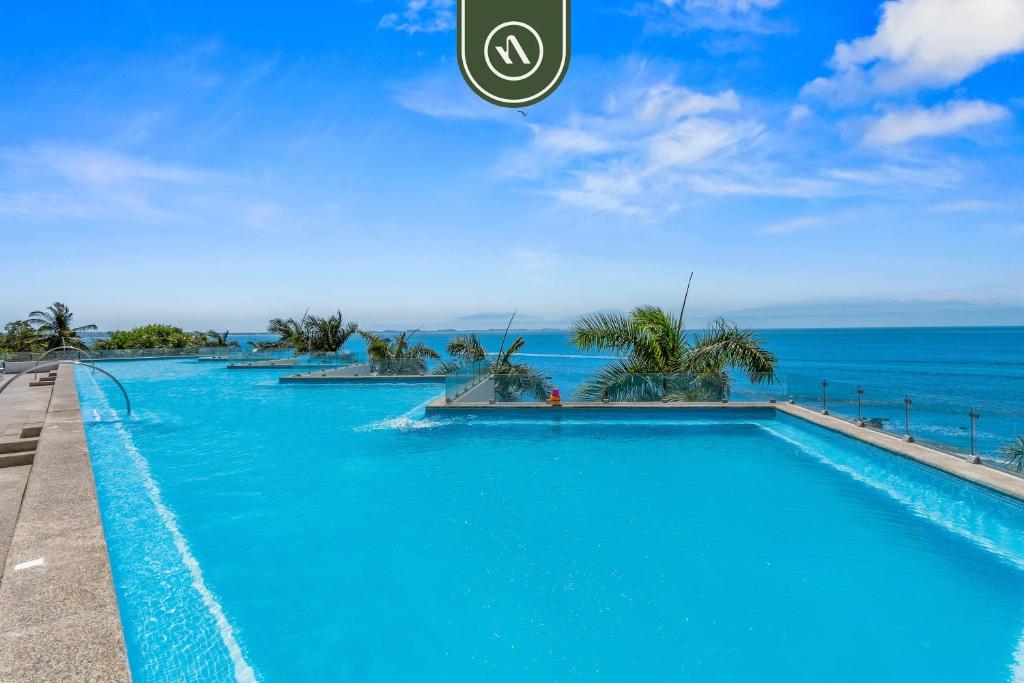 a swimming pool with a view of the ocean at Oceanfront 2 BR Condo with Beachclub in Cruz de Huanacaxtle