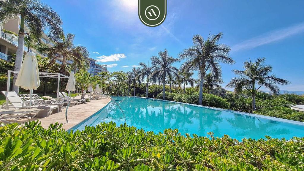 a swimming pool in a resort with palm trees at Oceanview Penthouse in Punta Mita - Beach - Pools in Higuera Blanca