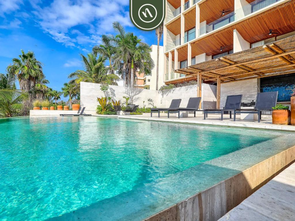 a swimming pool in front of a building at Luxury 4BR Oceanfront Condo - Private Beach - Pool in Cruz de Huanacaxtle