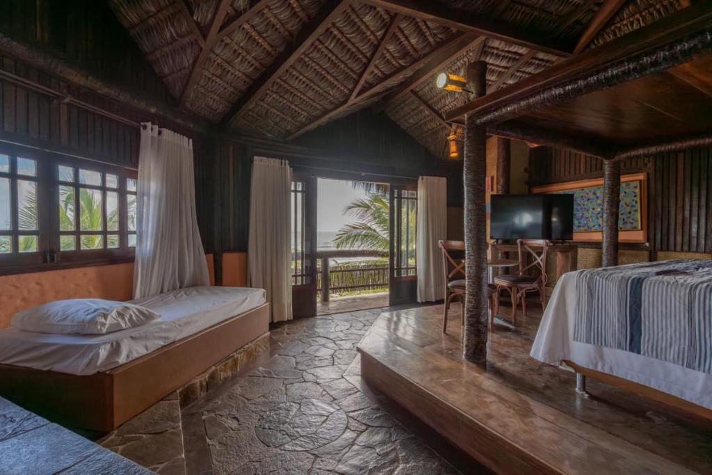 Un dormitorio con una cama y un televisor. en Dayo Hotel, en Flecheiras