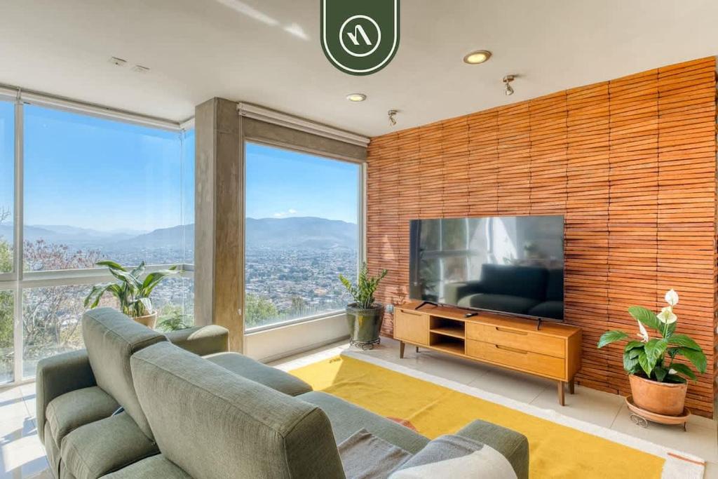 a living room with a couch and a flat screen tv at 3 BR Condo - Panoramic Views - 5 Min to Downtown in Oaxaca City