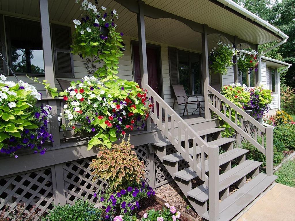 a porch of a house with flowers on it at Ole and Lena's Place in Bayfield