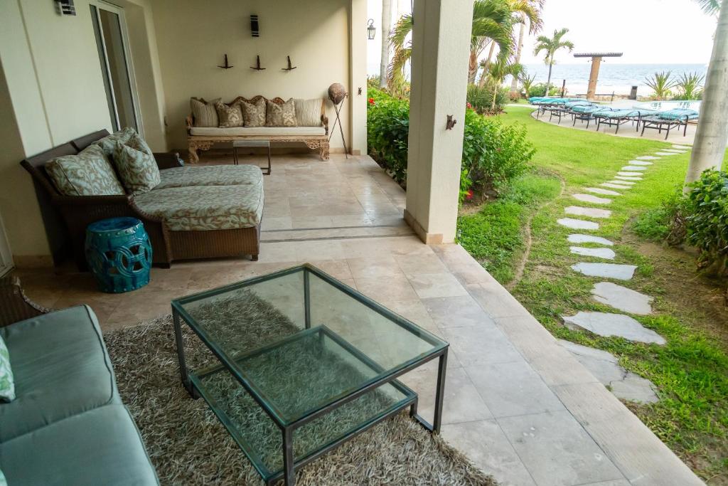 een woonkamer met een glazen salontafel op een terras bij Tortuga Bay TBB 2102 in San José del Cabo
